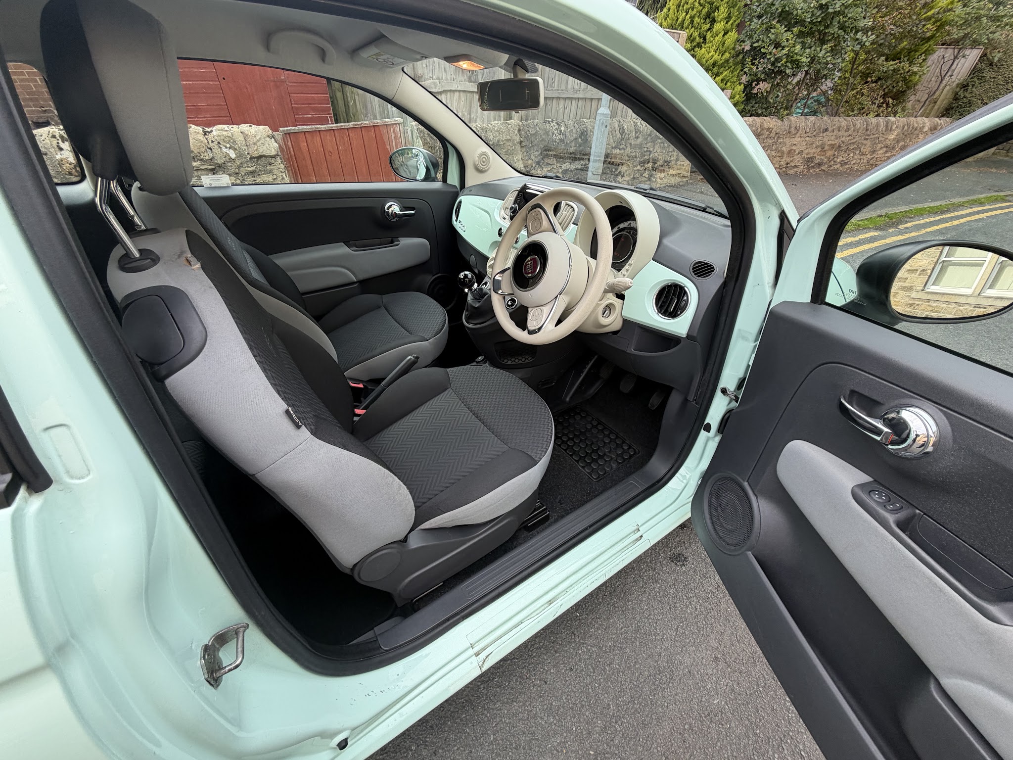 Clean Fiat 500 front seats and dashboard with its door open